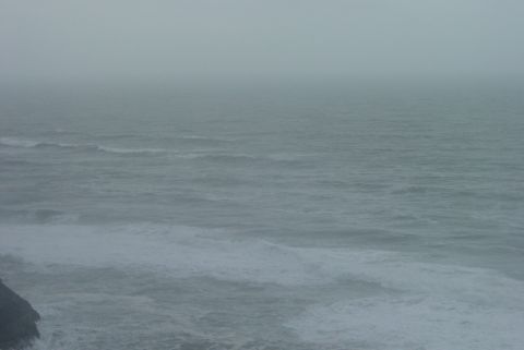 1993 Ford Bronco - The choppy ocean meets a rocky coastline on a foggy day.