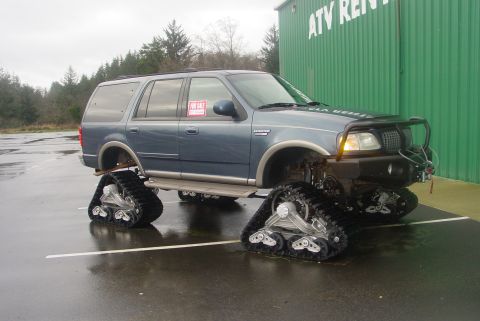 1993 Ford Bronco - This modified SUV is equipped with tracks for off-road use and is parked outside an ATV rental building.