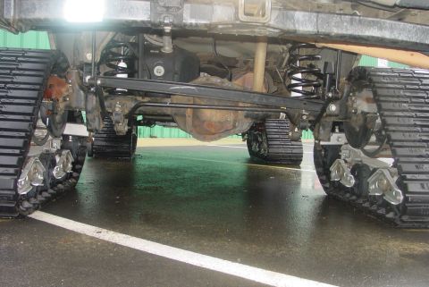 1993 Ford Bronco - This vehicle has been modified with tracks instead of wheels, showing its undercarriage and suspension system.