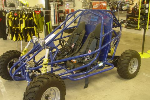 1993 Ford Bronco - A blue dune buggy with a tubular frame and racing seats is displayed in a retail environment.