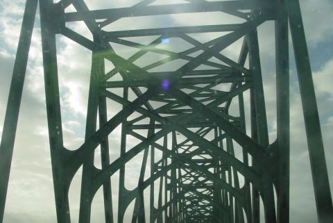 1993 Ford Bronco - Looking through the intricate metalwork of a bridge structure on a cloudy day.