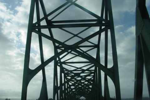 1993 Ford Bronco - Looking through the steel framework of a bridge on a cloudy day. Supermotors.net logo visible.