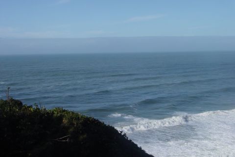 1993 Ford Bronco - A scenic view of the ocean and coastline, with waves breaking on the shore.