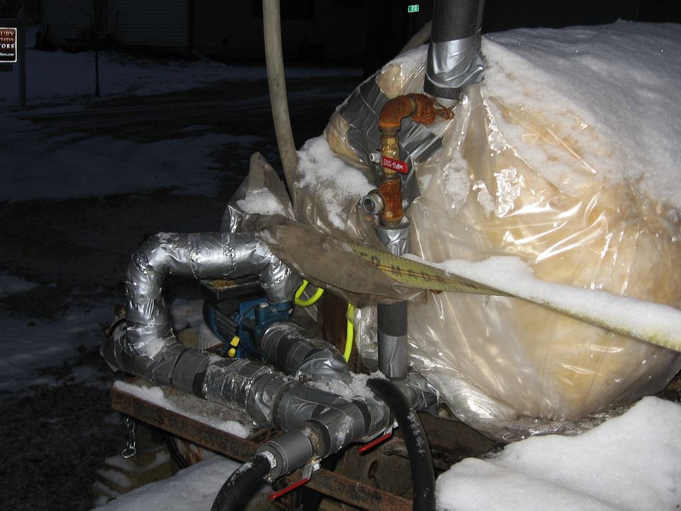 The plumbing.  Pump output flows through an in-line heater (6500W @ 220V) then into the drum through a Rilla Biofuels' 2-Pipe Drum Port through the long tube.  Pump return is through the short tube with a 90deg fitting so it draws "down" from the glycerin flow in the drum.  Condenser is plumbed in the top, smaller port on the drum.
