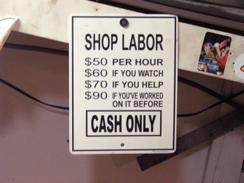 1989 Ford Probe - This sign details shop labor rates, with higher prices for customers who watch or help with the work.