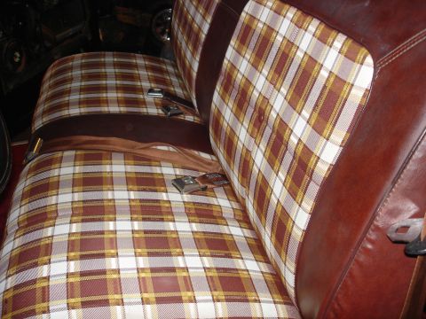 1979 Ford F-150 - The interior features a distinctive plaid pattern on the bench seat, accented by brown leather.