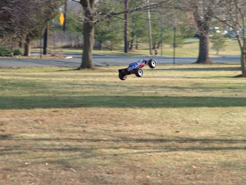 1994 Ford Bronco - Remote control buggy captured mid-flight over a lawn with trees in the background.