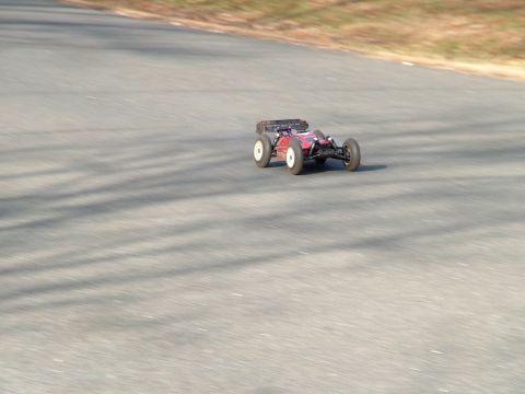 1994 Ford Bronco - A remote control buggy races on a paved track with shadows from trees.