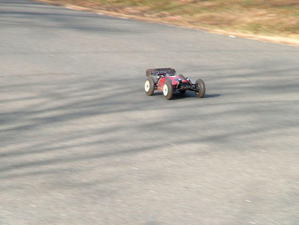 red remote control buggy on asphalt track