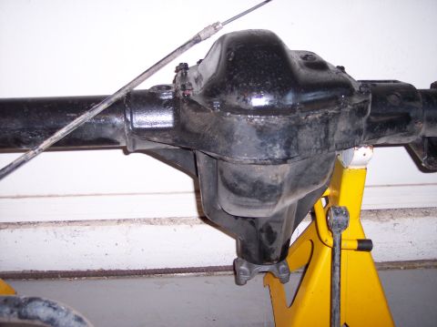 1996 Ford Bronco - Rear axle differential housing supported by jack stands, with a cable running overhead.