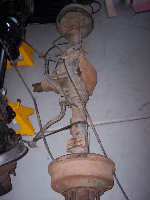 1996 Ford Bronco - A rear axle assembly, likely from a truck or SUV, is shown with drum brakes and suspension components.
