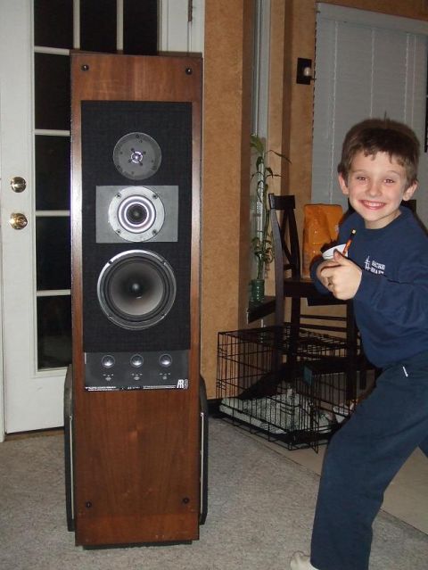 1987 Ford Bronco - A boy stands next to a large wooden speaker with multiple drivers, possibly an AR model.