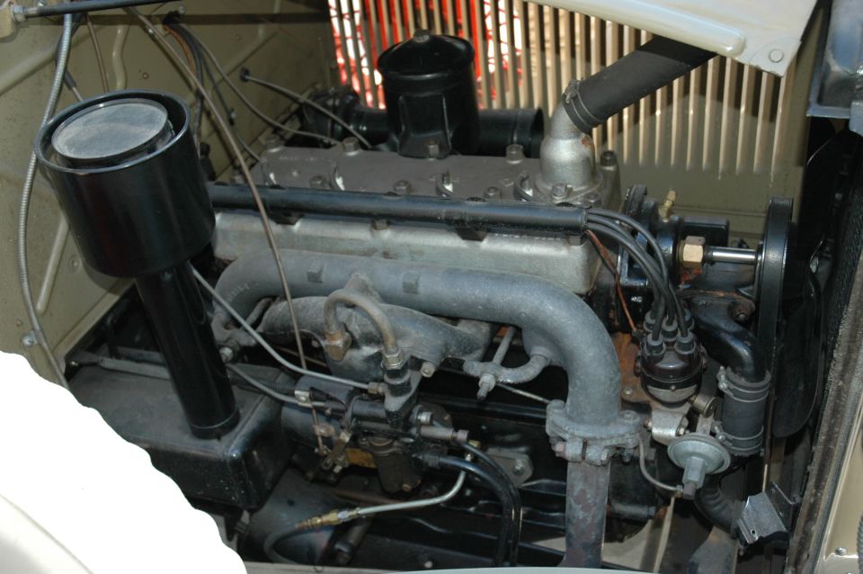 Vintage inline flathead engine with black oil-bath air cleaner in engine bay