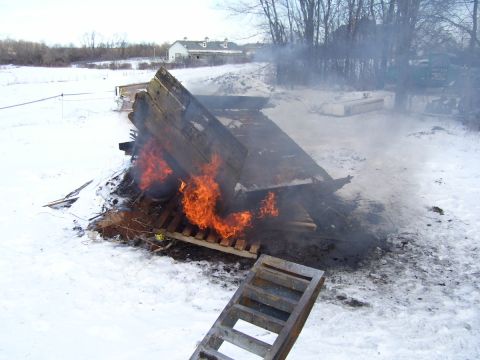 1979 Ford Pickup - A wooden structure burns in a snowy landscape, with smoke rising into the air.