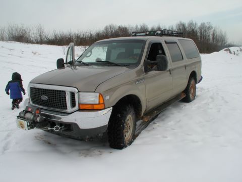 2000 Ford Excursion - A tan Ford Excursion with a winch on the front bumper is parked in the snow.