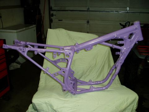 2000 Ford E350 - A freshly painted motorcycle frame sits on a stand in a garage.