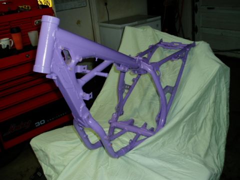 2000 Ford E350 - A freshly painted purple motorcycle frame rests on a cloth, with a red toolbox visible behind it.