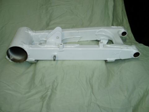 2000 Ford E350 - A white painted motorcycle swingarm is displayed on a draped surface.