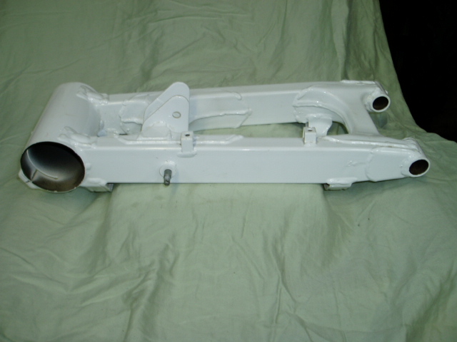White motorcycle swingarm on a green cloth background