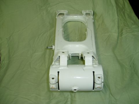 2000 Ford E350 - A white suspension part is shown against a green cloth, with visible bolts and slots.