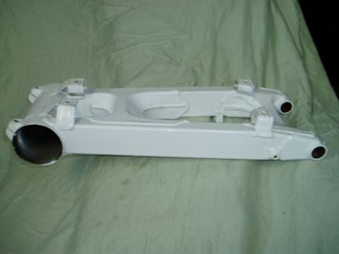2000 Ford E350 - White suspension part shown against a green fabric background. The part has two mounting brackets and openings at each end.