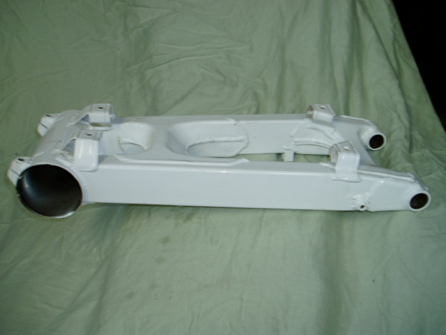 White suspension part with two mounting brackets and circular openings on each end