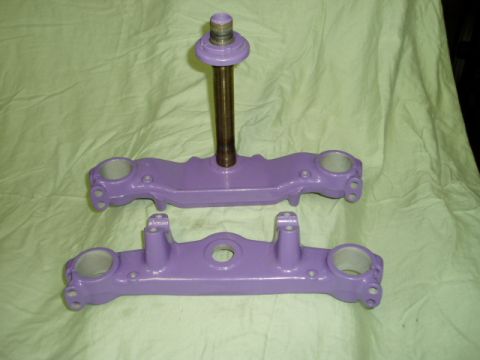 2000 Ford E350 - Motorcycle triple clamps, painted purple, are laid out on a light green cloth.
