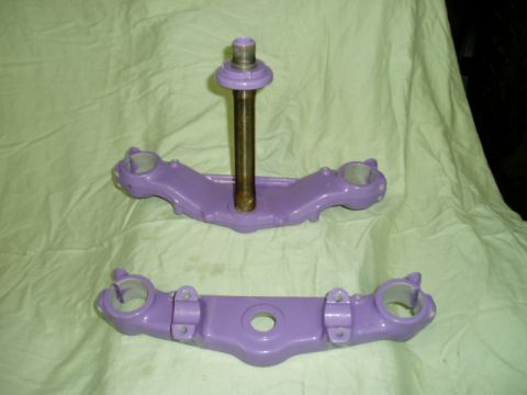 2000 Ford E350 - Two purple painted motorcycle triple clamps are displayed on a light green cloth background.