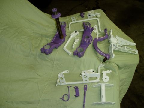 2000 Ford E350 - Various motorcycle parts, including triple clamps and foot pegs, are displayed after being painted.