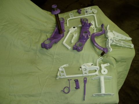 2000 Ford E350 - Various motorcycle components, painted purple and white, are arranged on a draped surface.