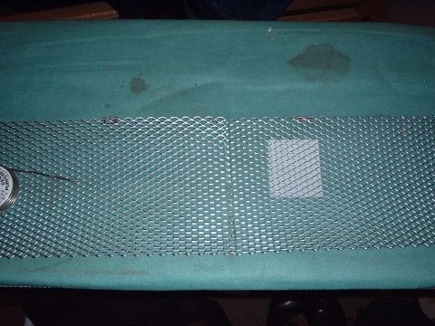 2000 Ford Taurus - A metal mesh grille is shown, with a small gauge visible on the left side of the frame.