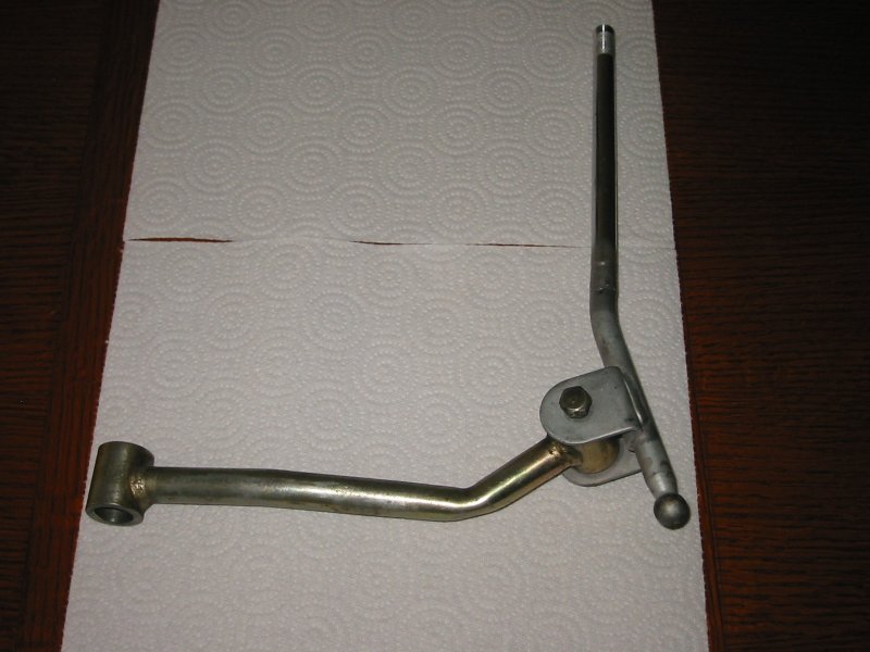 Metal manual transmission shift lever assembly on white paper