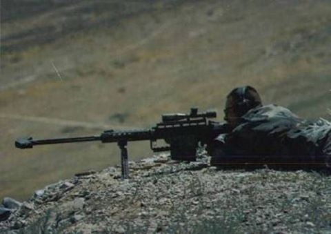 1967 Ford Ranchero - A sniper lies prone on a rocky hill, aiming a scoped rifle with a bipod.