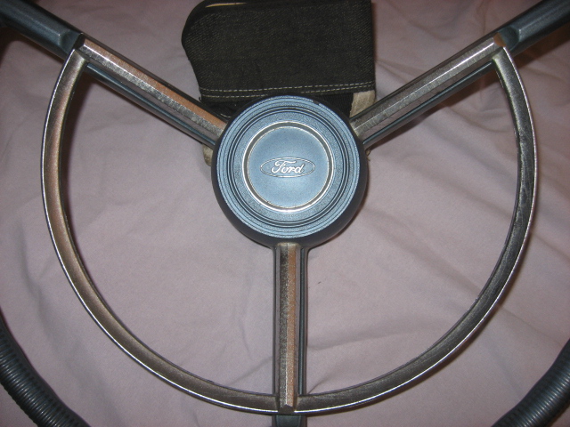 Ford steering wheel with blue horn button and chrome trim