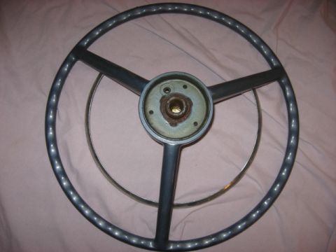 1972 Ford F-100 - A steering wheel, likely from an older vehicle, is shown against a pink background.