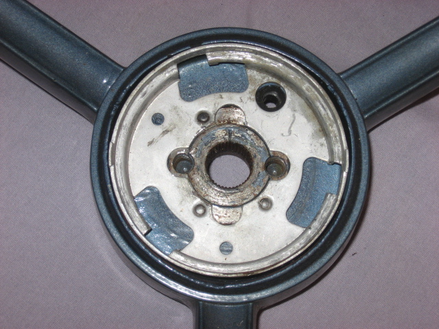 Gray steering wheel hub with three spokes visible