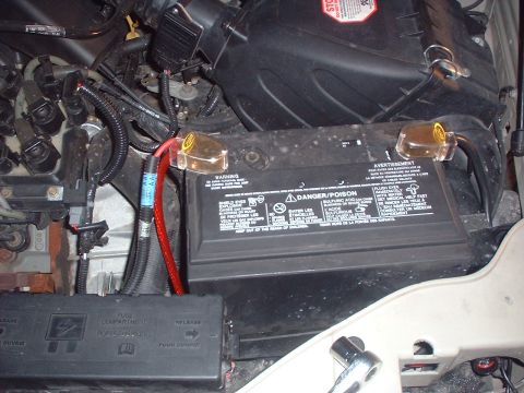 2000 Ford Taurus - Close-up view of a vehicle's engine compartment, focusing on the battery and associated components.