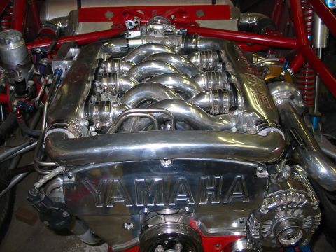 1993 Ford Taurus - Top view of a highly polished V6 engine installed in a red tube-frame chassis, with a custom equal-length tubular intake manifold, band-cla…