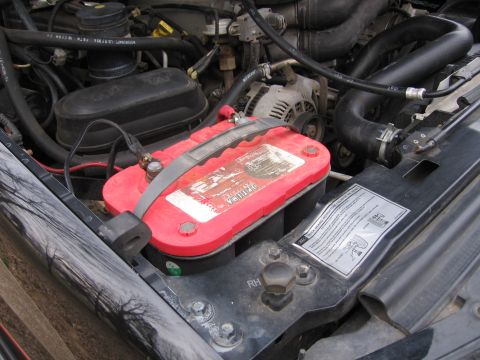 1967 Ford Mustang - Close-up view of a red Optima battery located within a vehicle's engine compartment.
