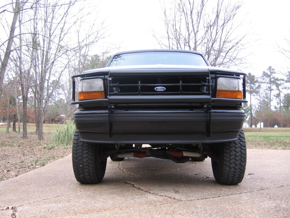 Front view of a black Ford Bronco with a brush guard and off-road tires