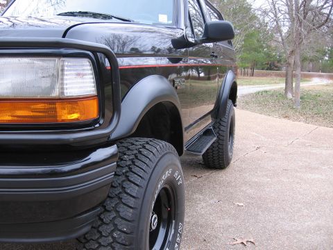 1967 Ford Mustang - Front corner view of a black Ford Bronco, showing its aggressive tires and fender flares.