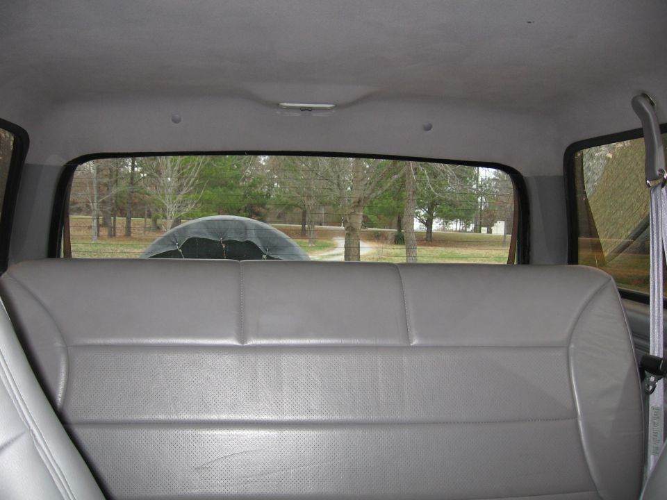 Rear seat and spare tire visible through the back window of an SUV