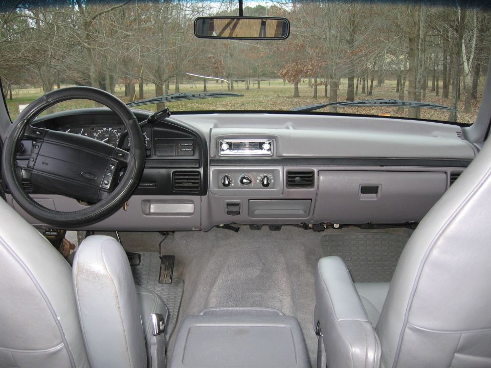 Gray interior of a 1992 Ford Bronco with a black steering wheel and dashboard
