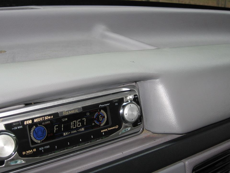 Dashboard interior with Pioneer Premier stereo, showing F1 106.7 display