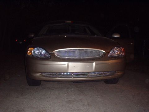 2000 Ford Taurus - A gold 2000 Ford Taurus is shown from the front at night, an aftermarket grille.