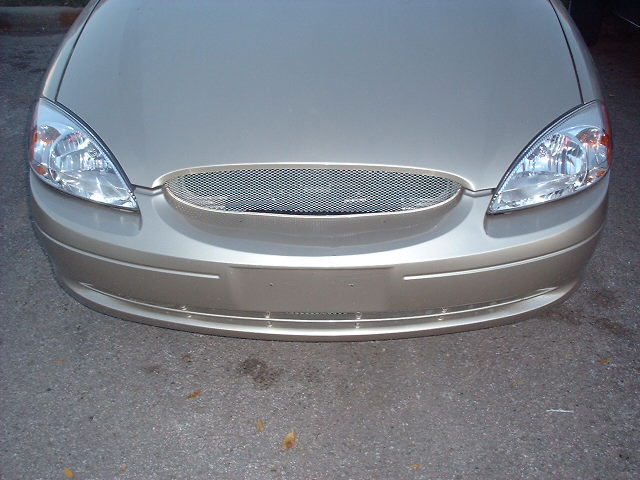 Front view of a gold 2000 Ford Taurus showing headlights, grille, and bumper