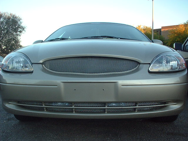 Gold 2000 Ford Taurus front view, aftermarket grille, some damage to lower bumper