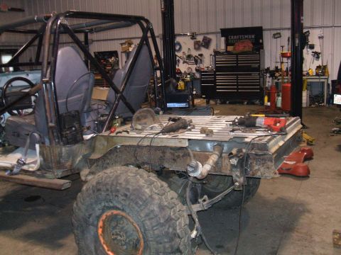 1995 Ford Bronco - This Jeep CJ-7 is undergoing modifications in a garage, with tools and equipment visible in the background.