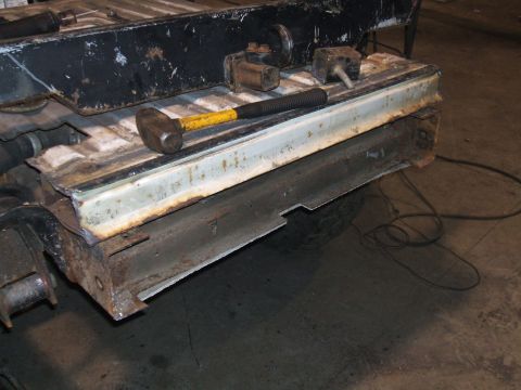 1995 Ford Bronco - A section of a vehicle frame, showing significant rust and damage, with tools laid out on top.