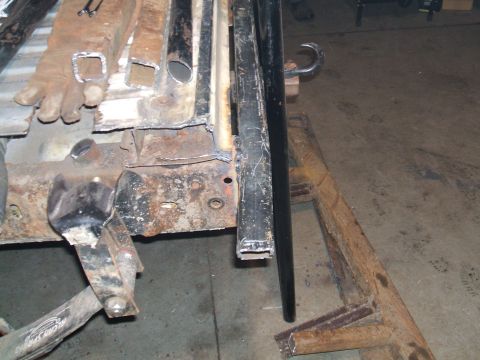 1995 Ford Bronco - Close-up view of rusted metal frame components and parts, possibly undergoing repair or modification.